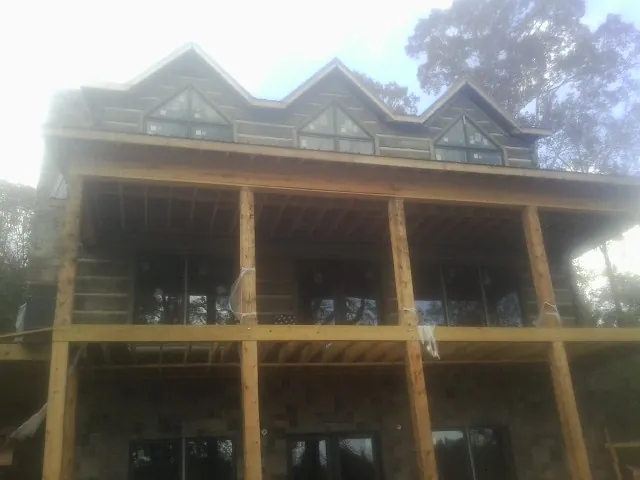 Dormers and porch framing on a large log home under construction — Roof Coating work by our crew in Copperas Cove