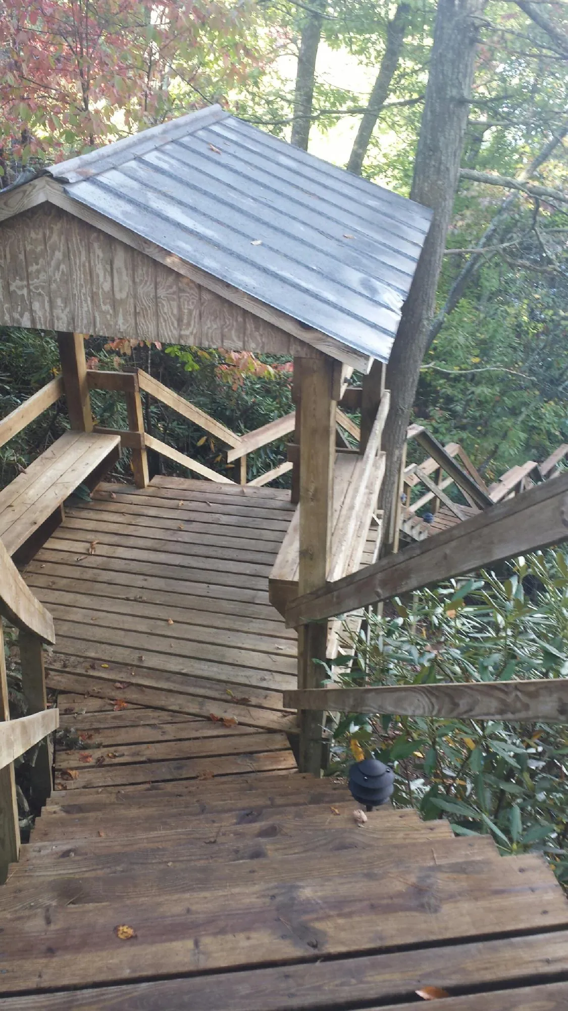 Metal roofed shelter over wooden steps on a wooded walkway — Skylight Repair & Installation work by our crew in Copperas Cove