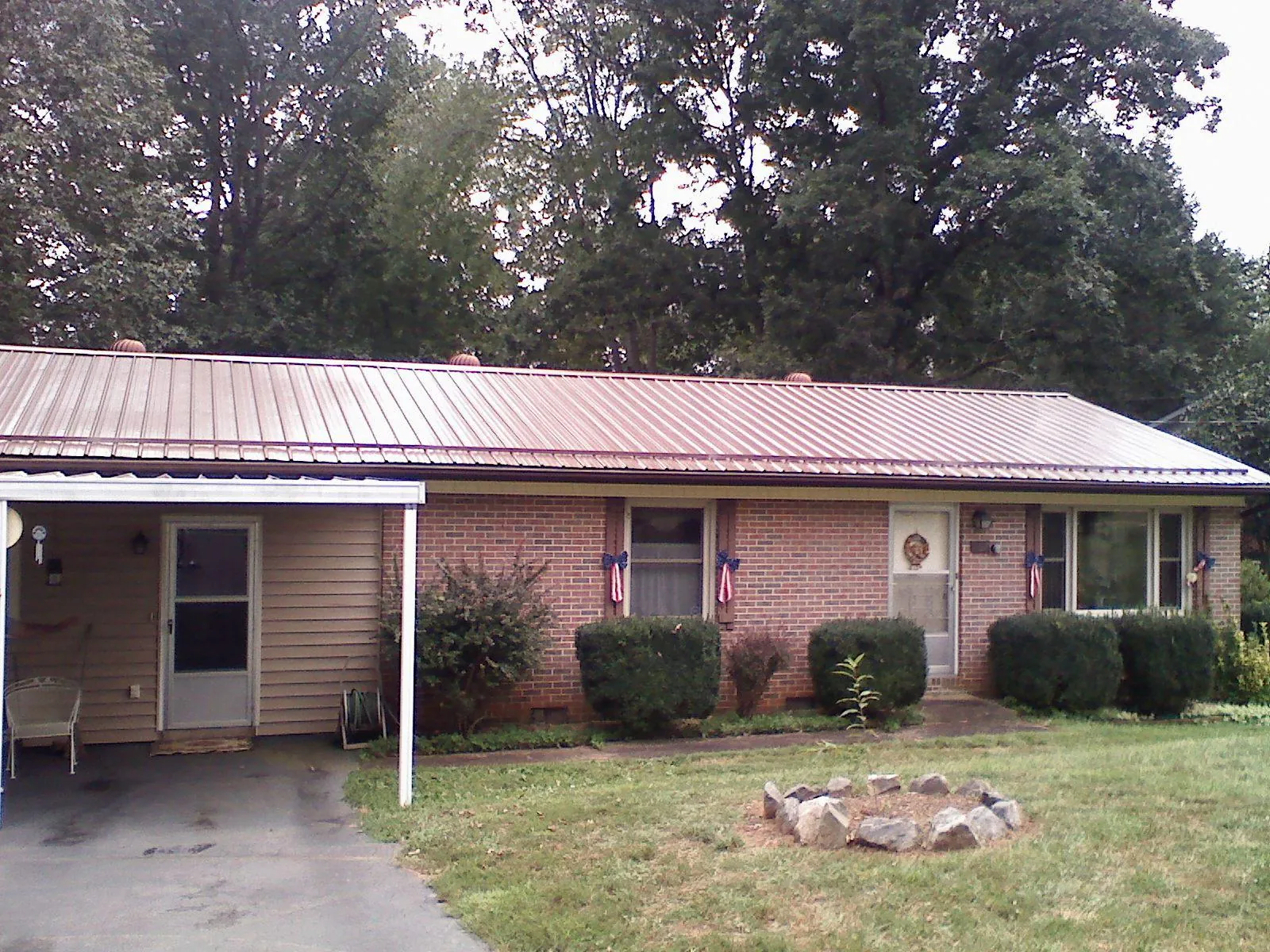 Bronze metal roof and carport on a brick ranch home — Roof Repair work by our crew in Copperas Cove