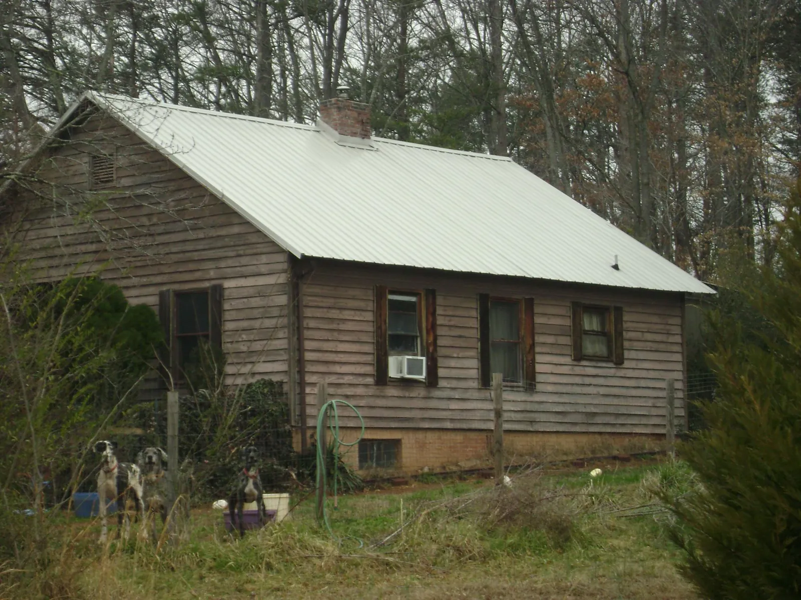 White metal roof on an old wood sided farmhouse, from a Asphalt Shingle Roof Repair job in Copperas Cove